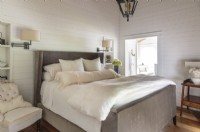 Un luxueux lit rembourré en velours est la pièce maîtresse de la chambre.