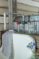 Un vieil évier de concierge réutilisé comme accessoire de salle de bain.
