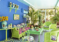 Un mobilier coloré crée une ambiance tropicale dans un autre porche couvert.