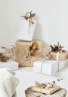 Cadeaux de Noël emballés en marron et blanc avec des décorations naturelles