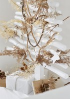 Feuilles de fougère séchées sur des décorations de perles sur l'arbre de Noël blanc