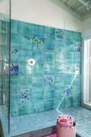 Des carreaux de verre commandés à un artiste local créent une fresque étincelante dans la salle de bain principale.