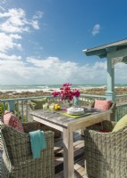 Osier classique et confortable, et couleurs aussi vives qu'une corbeille de fruits tropicaux prolongent un accueil chaleureux sur le balcon donnant sur la plage.