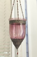 Une lanterne de style marocain équipée d'une bougie chauffe-plat attend que le crépuscule brille.