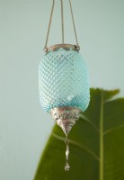 Une lanterne aqua en verre taillé ajoute une touche d'intrigue et complète la palette de couleurs.