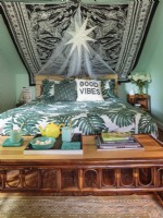 Une parure de lit feuillue à grande échelle et une table basse en rotin apportent une ambiance tropicale à la chambre.