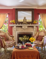 Une paire de chaises dorées recouvertes de luxueuses soies vintage et de rideaux aux tons miel favorisent un sentiment d'opulence.