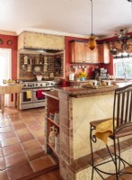 Avec ses tons chauds, ses murs en plâtre, ses pierres, ses briques et ses carrelages, la cuisine est un bureau de style toscan.