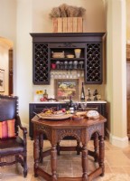 Dans le séjour, un espace est dédié à une « cave à vin » comprenant un fauteuil en cuir vintage, une table en noyer et, bien sûr, une cave à vin.