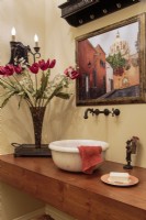 Des fonds baptismaux provenant d'une chapelle européenne sont mis en service dans la salle de bain des invités.