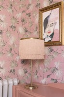 Lampe de table de style art déco à franges sur une commode récupérée devant du papier peint à motifs de feuilles de palmier