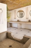 Salle de bain avec finitions en béton et plafond en roseau