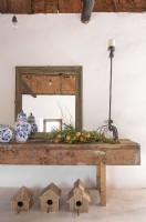 Miroir, céramique, fruits et bougeoir sur une ancienne table d'atelier