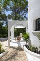Pergola intégrée sur terrasse blanche de maison de campagne en été