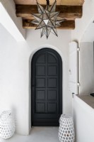Porte en bois peinte en noir avec encadrement mural blanc