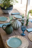 Vaisselle bleue et verte sur table à manger extérieure en bois - détail
