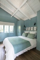 Murs en bois peints en bleu dans une chambre de campagne