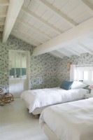 Chambre champêtre avec papier peint fleuri et sol peint en blanc