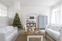 Salon de campagne moderne peint en blanc décoré pour Noël