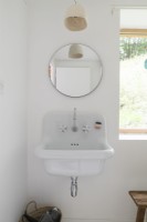 Lavabo de salle de bain de style vintage avec miroir circulaire au-dessus