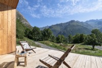Chaises en bois sur la terrasse avec vue panoramique sur les montagnes