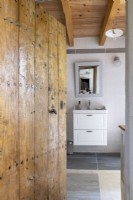 Vue à travers la vieille porte en bois cloutée vers la salle de bains