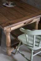 Détail d'une table à manger en bois et d'une chaise peinte en bleu pâle