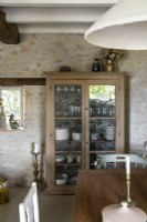 Commode en bois contre mur en pierres apparentes dans la salle à manger de campagne