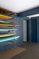 Couloir moderne peint en gris foncé avec support de rangement pour planche de surf