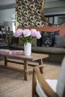 Fleurs dans un vase sur une table basse en bois dans un salon moderne