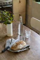 Détail de miche de pain rustique sur table de cuisine en bois