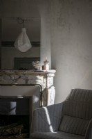 Fauteuil moderne à côté de la cheminée en marbre classique