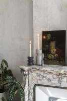 Détail de la peinture et des bougies sur une cheminée en marbre