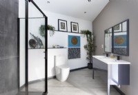 Oeuvres d'art et plantes d'intérieur dans une salle de bains contemporaine