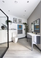 Oeuvres d'art et plantes d'intérieur dans une salle de bains contemporaine minimaliste