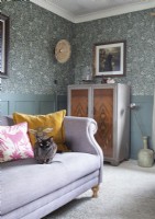 Chat de compagnie sur un canapé violet dans un salon de style classique