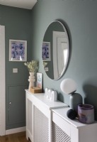 Etagère de cache-radiateur blanc et miroir dans le couloir peint en gris