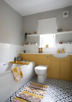 Salle de bain jaune et blanche avec sol monochrome à motifs