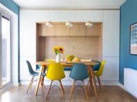 Chaises bleues et jaunes autour d'une table à manger en bois avec siège en alcôve