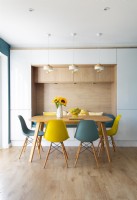 Chaises bleues et jaunes autour de la table à manger avec banquette intégrée