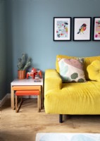 Canapé jaune et tables gigognes orange dans un salon coloré