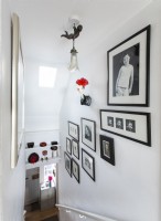 Photographies encadrées en noir et blanc sur le mur de l'escalier