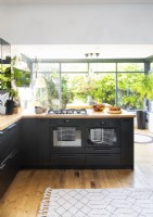 Fours doubles avec cuisinière à gaz dans une cuisine moderne avec vue sur le jardin