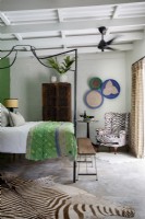 Chambre avec lit à baldaquin en métal et décoration éclectique