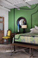 Chambre avec lit à baldaquin en métal et mur végétal