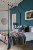 Chambre avec lit à baldaquin et mur décoratif bleu sarcelle