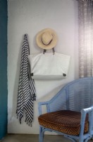 Sarong, sac et chapeau de soleil suspendus au-dessus d'une chaise en rotin
