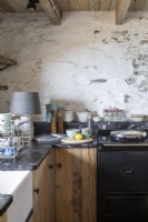 Plan de travail de cuisine avec cuisinière Aga et murs blanchis à la chaux