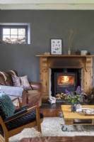 Maison de Sally et John Biddle à Cornwall, salon gris et blanc avec poêle à bois et meubles du milieu du siècle