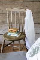 Détail dans la chambre d'une chaise en bois et de livres vintage